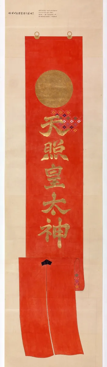 赤地の細長い旗の上部に金色の丸い日輪が描かれ、その下に金文字で「天照皇太神」と書かれている