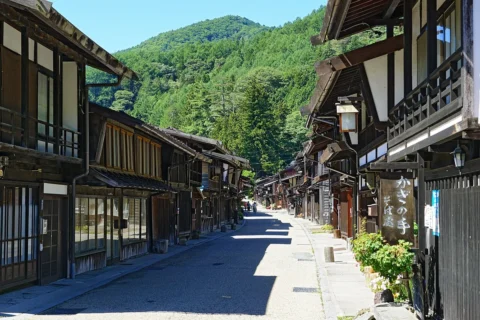 山を背にまっすぐ延びる通りの両側に、2階建ての木造の町家がすき間なく並び、屋根の端が通りの上に張り出して奥まで続いている