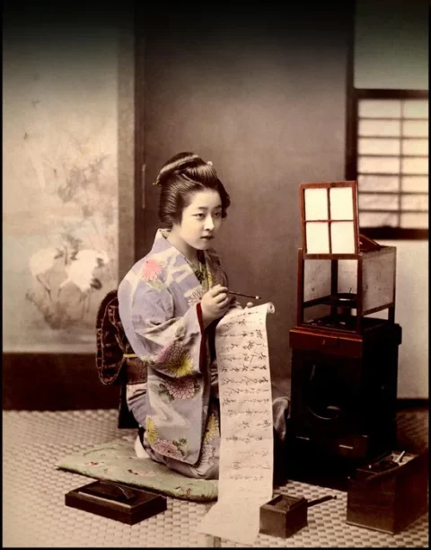 行灯の明かりのそばで手紙を書く女性